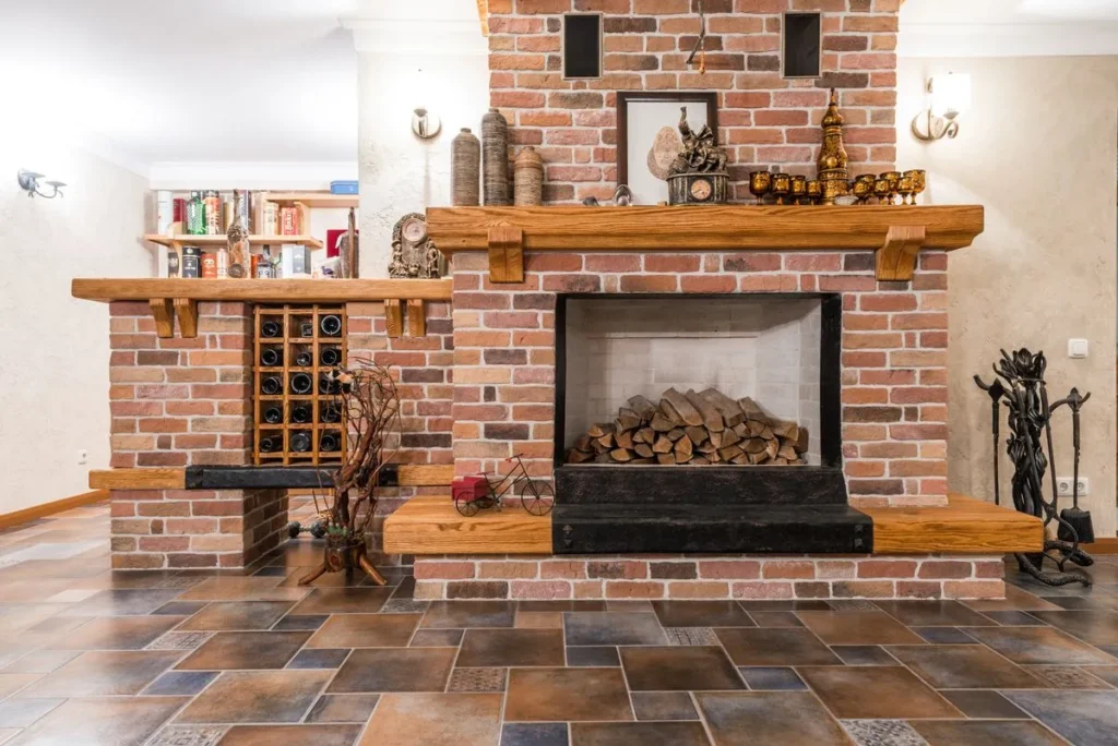 Brick fireplace with a wood mantel and stacked firewood in the firebox