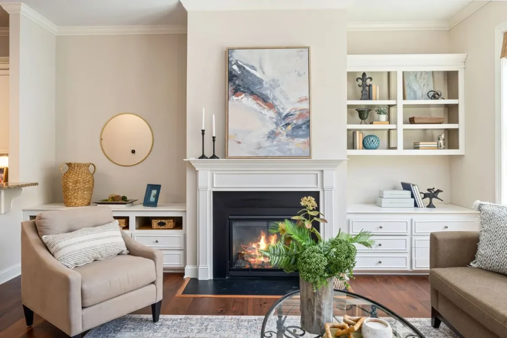 Living room with a lit fireplace, white mantel and built-in shelves