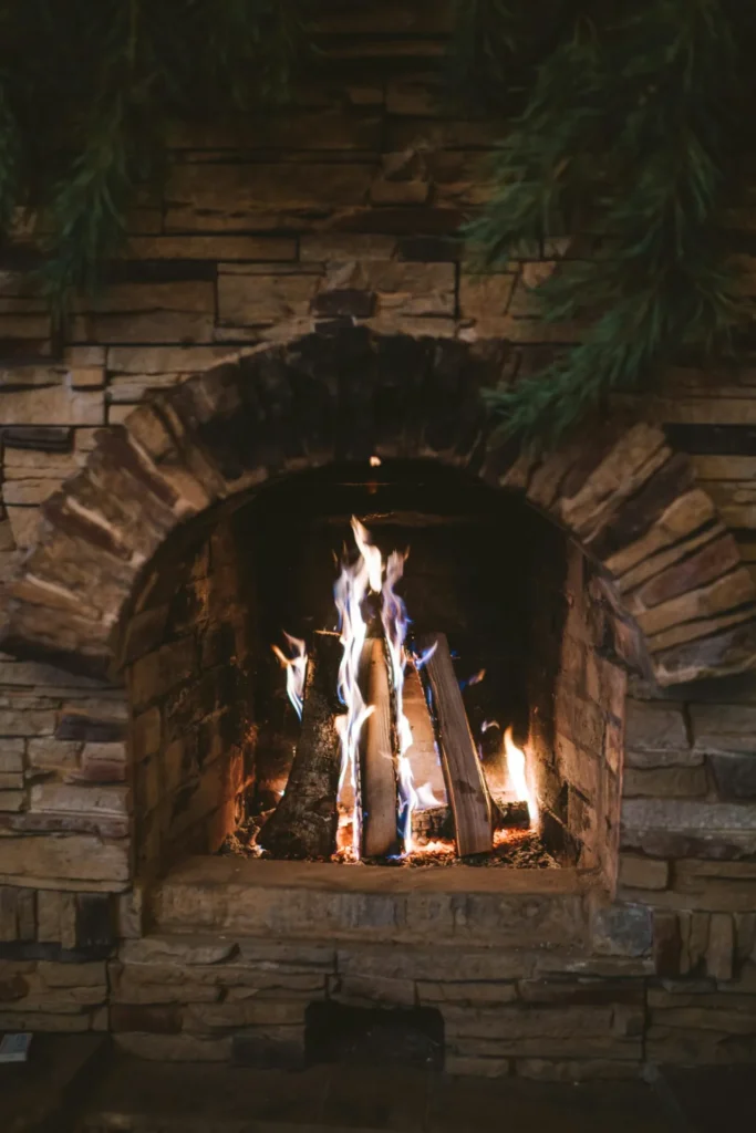 Wood fire burning in an arched stone fireplace