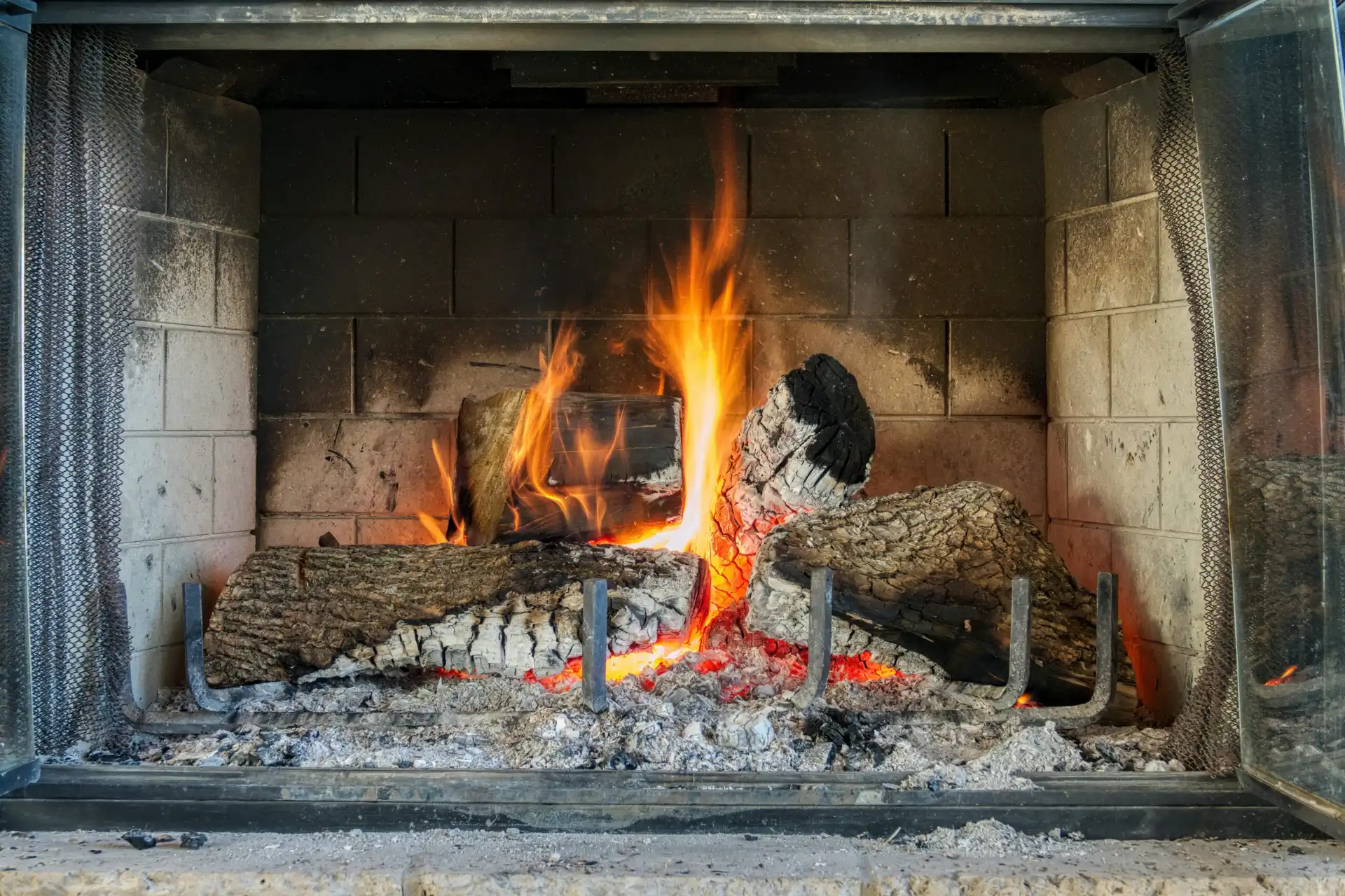 Wood fire burning on a grate in a brick fireplace