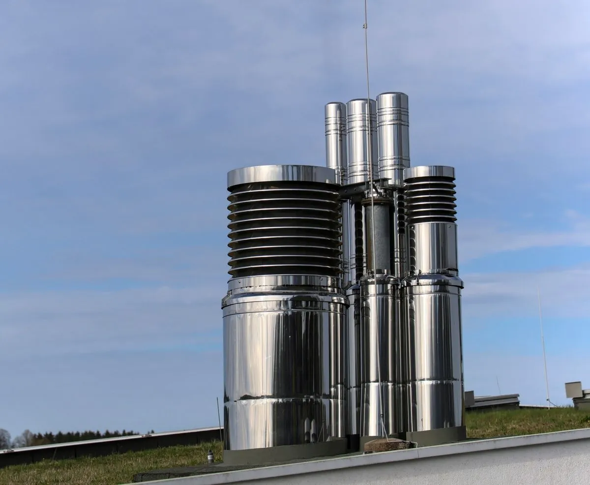 Stainless steel chimney flues with caps on a rooftop